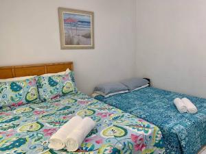 西湾SUITE 1, Blue Pavilion - Beach, Airport Taxi, Concierge, Island Retro Chic的一间卧室配有一张床,上面有两条毛巾