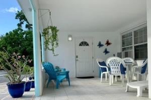 西湾SUITE 1, Blue Pavilion - Beach, Airport Taxi, Concierge, Island Retro Chic的一个带蓝白色椅子和门的庭院
