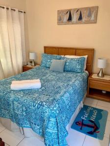 西湾SUITE 4, Blue Pavilion - Beach, Airport Taxi, Concierge, Island Retro Chic的一间卧室配有一张带蓝色棉被的床