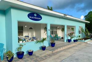 西湾SUITE 4, Blue Pavilion - Beach, Airport Taxi, Concierge, Island Retro Chic的前面有盆栽植物的蓝色建筑