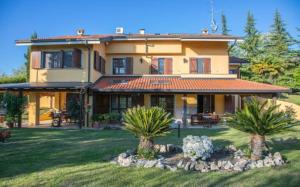 Rosignano MonferratoVilla intera San Marco - Luxury Wine Resort的庭院里种有棕榈树的大房子