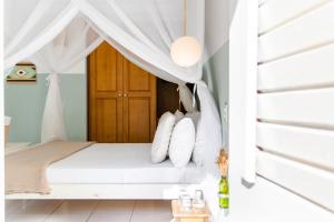 杰里科科拉Vila Charme的卧室配有带白色枕头的天蓬床
