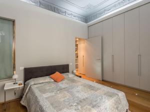 罗马Luxury Fori Imperiali Flat的一间卧室配有一张带橙色枕头的大床