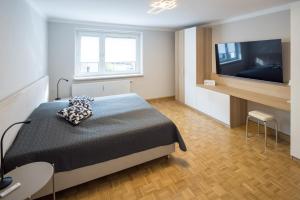 穆尔河畔布鲁克Top 4的一间卧室配有一张床和一台平面电视