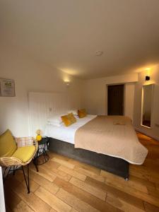 布罗肯赫斯特Cottage Lodge Hotel的一间卧室配有一张大床和一把椅子