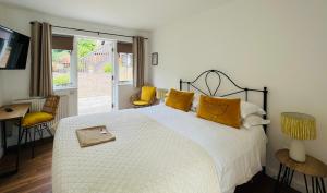 布罗肯赫斯特Cottage Lodge Hotel的卧室配有一张带黄色枕头的大型白色床。