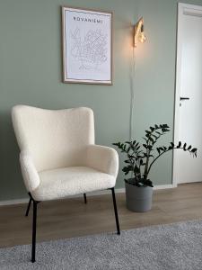 罗瓦涅米Brand New! Villa Moon的白色椅子,在种植盆栽的房间里