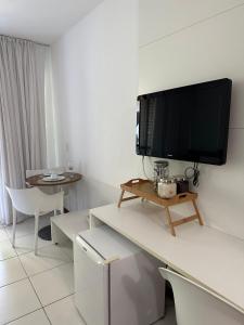 拉巴拉德纳圣米格尔Ap. Vista pra piscina - Iloa的一间客厅,在白色的墙上配有电视