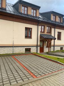 卡什佩尔斯凯霍里Apartmán v Kašperských Horách的建筑前有鹅卵石车道的房子