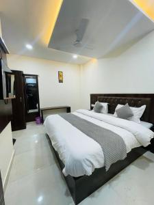 哈里瓦Divine Ganga by MJ Hospitality的一间卧室配有一张带白色床单的大床