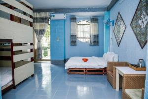 迪石Bụi Hostel - Bến Tàu Rạch Giá的蓝色的客房配有床和水槽