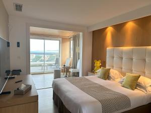 卡尔维Hotel Revellata & Spa的酒店客房设有一张大床和一张书桌。