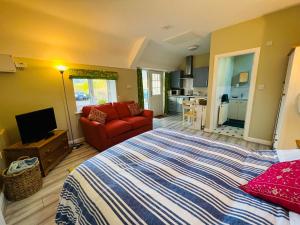 LlanferresPentre Cerrig Country House的一间卧室配有一张大床和一张红色的沙发
