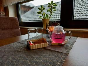梅德巴赫Ferienwohnung Martina的一张桌子上装有粉红色液体的玻璃罐