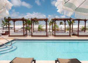 拉帕尔格拉Parguera Plaza Hotel - Adults Only的一个带椅子和遮阳伞的游泳池