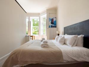 伦敦Pass the Keys Gorgeous studio with access to a private garden的一间卧室配有一张大床和毛巾