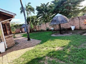 MtubatubaGREEN TREE的庭院里设有带桌子和遮阳伞的庭院。