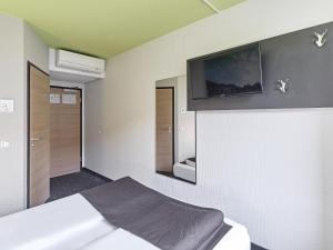 科隆科隆机场B&B酒店的卧室配有一张床,墙上配有电视。