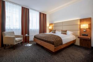维也纳Hotel IMLAUER Wien的配有一张床和一把椅子的酒店客房
