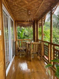 MahinogCamiguin Blue Lagoon Cottages的一个带桌椅的房屋门廊