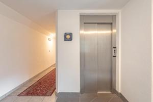 圣克里斯蒂娜苏瓦尔公寓的走廊上的电梯,墙上有时钟
