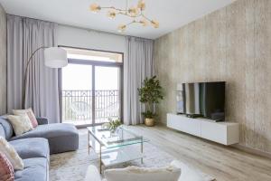 迪拜Nasma Luxury Stays - Fabulous Apartment With Balcony Near MJL's Souk的带沙发和电视的客厅