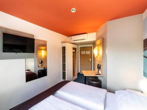 康斯坦茨康斯坦茨住宿加早餐酒店的酒店客房,设有一张橙色天花板的床
