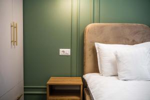 苏恰瓦匝姆卡苏恰瓦酒店的一间卧室设有绿色的墙壁和一张带桌子的床