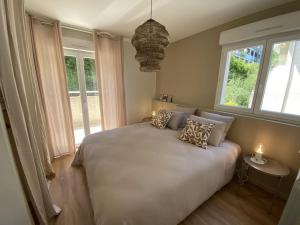 埃维昂莱班Magnifique Appart rénové Hauteur Evian vue Lac 8 pers的卧室配有白色的床、枕头和窗户。