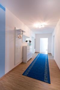 BurtenbachFerienparadies Amadeus的客厅的地板上铺有蓝色地毯。