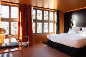 里昂Pilo Lyon的酒店客房设有一张床、一张书桌和窗户。