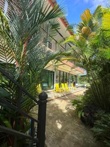 麦岛Hanoii House的一座棕榈树和黄色椅子的房子