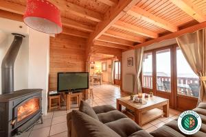 圣若里奥ST JORIOZ- Cosy Chalet vue lac et montagnes - LLA Selections by Location Lac Annecy的带沙发和壁炉的客厅