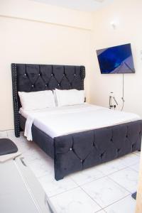 蒙巴萨The Nest Studio Apartment in Bamburi Mombasa的一张大床,在房间里设有黑色床头板