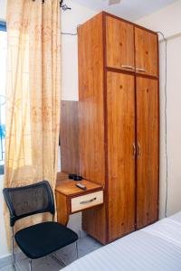 蒙巴萨The Nest Studio Apartment in Bamburi Mombasa的一间卧室配有一张床、一张桌子和一把椅子
