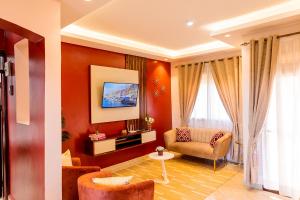 坎帕拉Premier Suites Kyanja的带沙发和电视的客厅