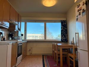 赫尔辛基An entire flat 60m2 with a balcony in Itakeskus of Helsinki的厨房配有桌子和大窗户