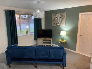 HednesfordThe Uxbridge Suite的客厅配有蓝色的沙发和电视