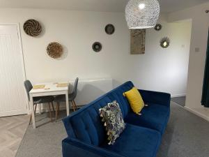 HednesfordThe Uxbridge Suite的客厅配有蓝色的沙发和桌子