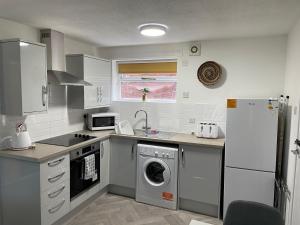 HednesfordThe Uxbridge Suite的厨房配有洗衣机和冰箱。