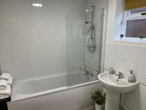 HednesfordThe Uxbridge Suite的带淋浴、盥洗盆和浴缸的浴室