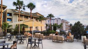 锡德Side Zeugma Hotel - Adult Only 16 Plus的一个带桌椅的庭院,棕榈树