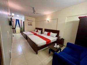 卡拉奇Hotel 7 DHA的一间卧室配有一张床和一张蓝色的沙发