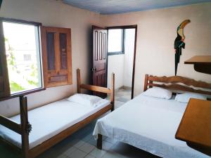 莱蒂西亚Divino Niño Hotel的配有桌子和窗户的客房内的两张床
