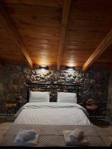 卡拉维塔Villas Kertezi的卧室配有一张石墙床