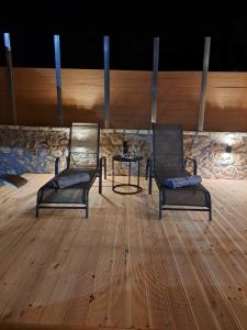 卡拉维塔Villas Kertezi的木地板上配有两把椅子和一张桌子