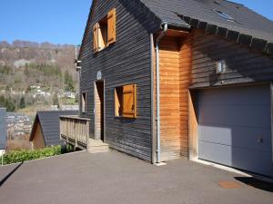 勒蒙多尔Chalet Mont-Dore, 5 pièces, 8 personnes - FR-1-608-223的黑色房子,带车库和车道