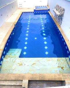 比列塔Hotel Tradicional Villeta的大型蓝色游泳池,铺有瓷砖地板