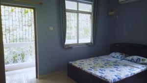 波戈马洛Yago's Hideout的一间卧室设有一张床和两个窗户。