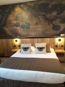 尼奥尔法国酒店的一间卧室设有一张带木墙的大床
